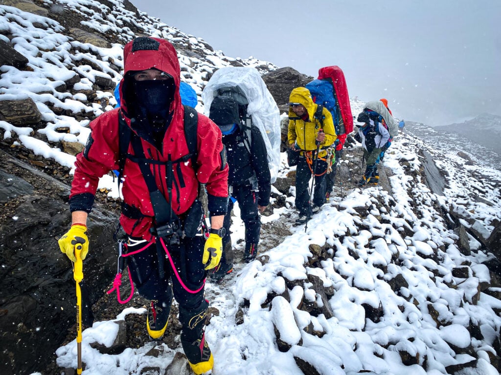 a group of people hiking up a snow covered mountain