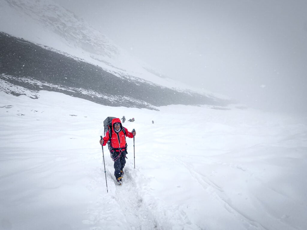 a man in a red jacket is cross country skiing