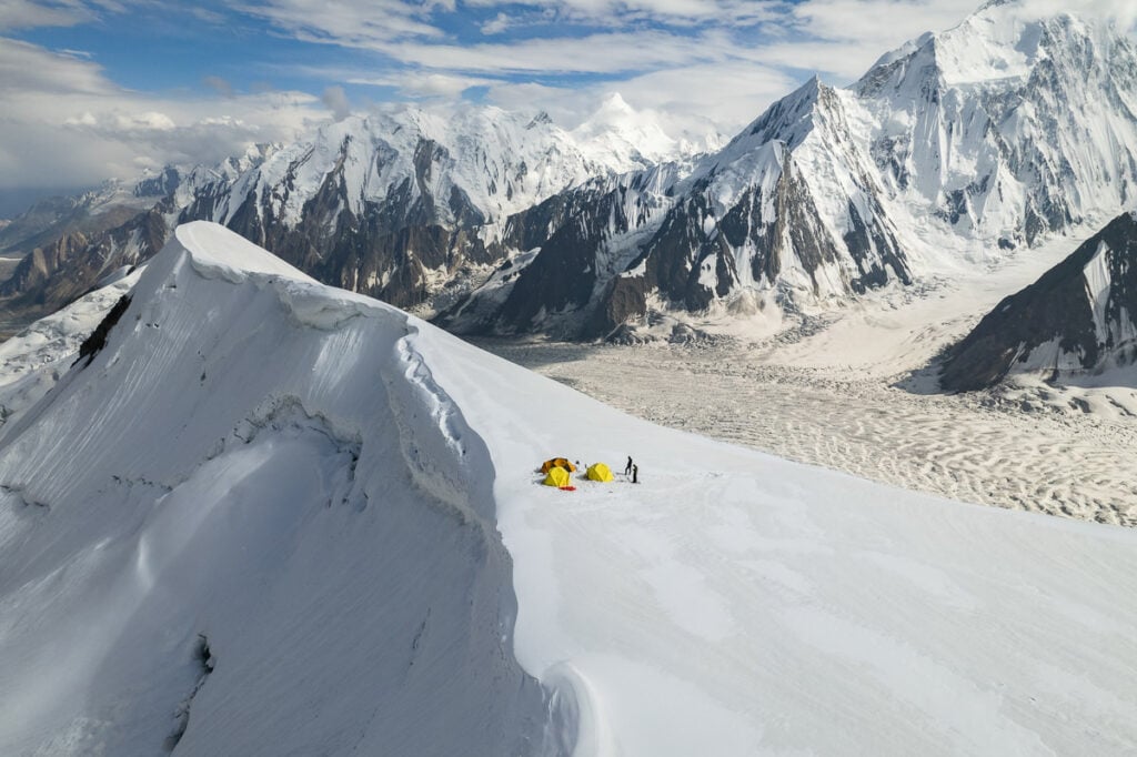 a group of people standing on top of a snow covered mountain