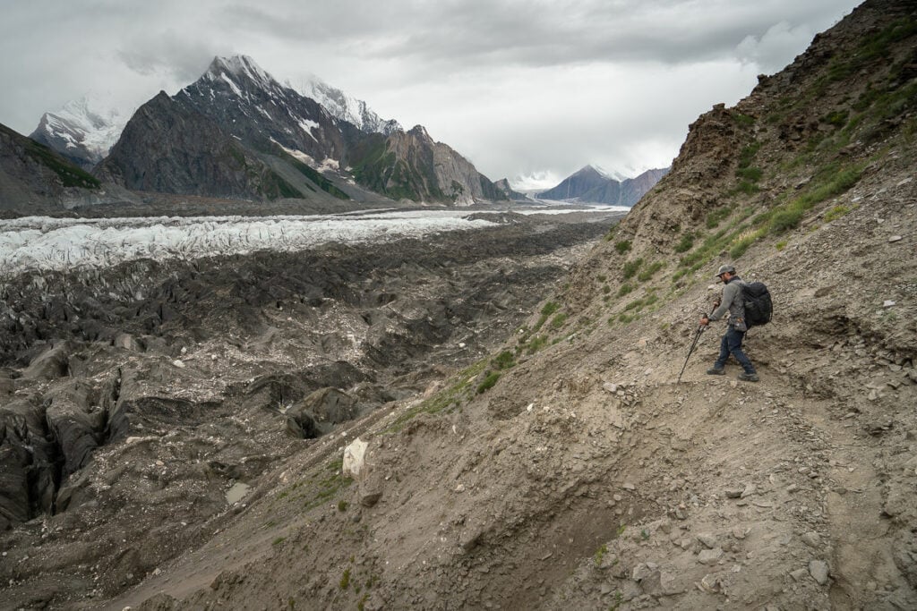 a man with a backpack walking up a hill