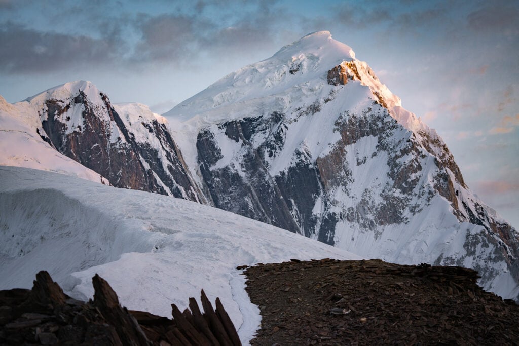 a snow covered mountain with a fence in the foreground