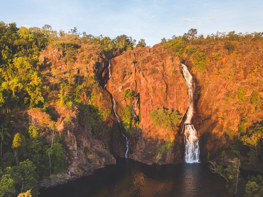 a waterfall in the middle of a lush green forest.