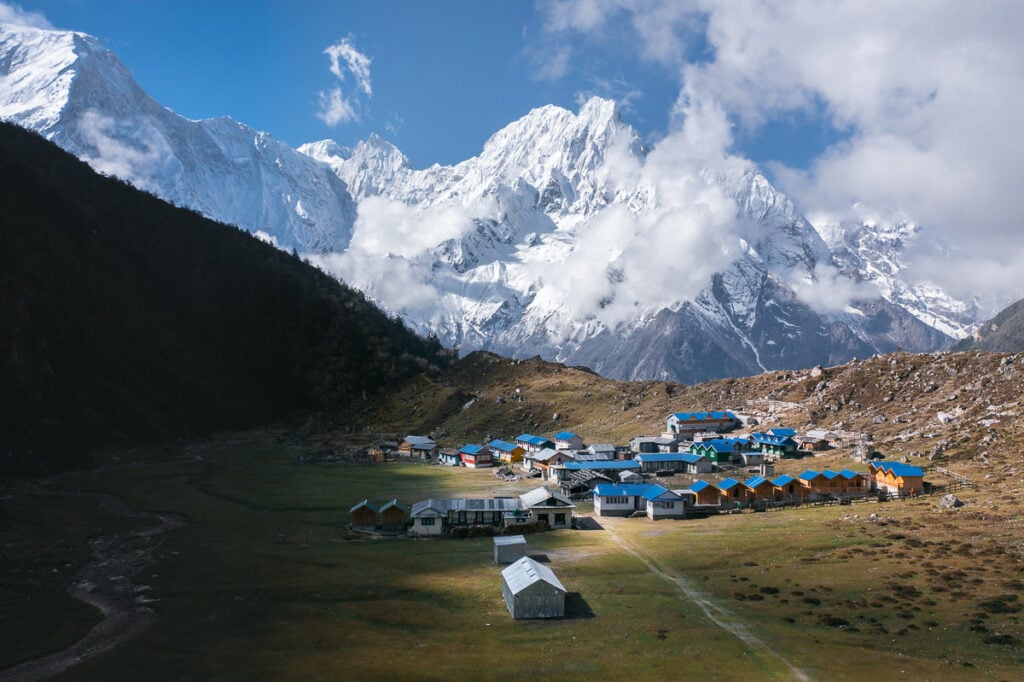 a scenic view of a mountain range with a village in the foreground