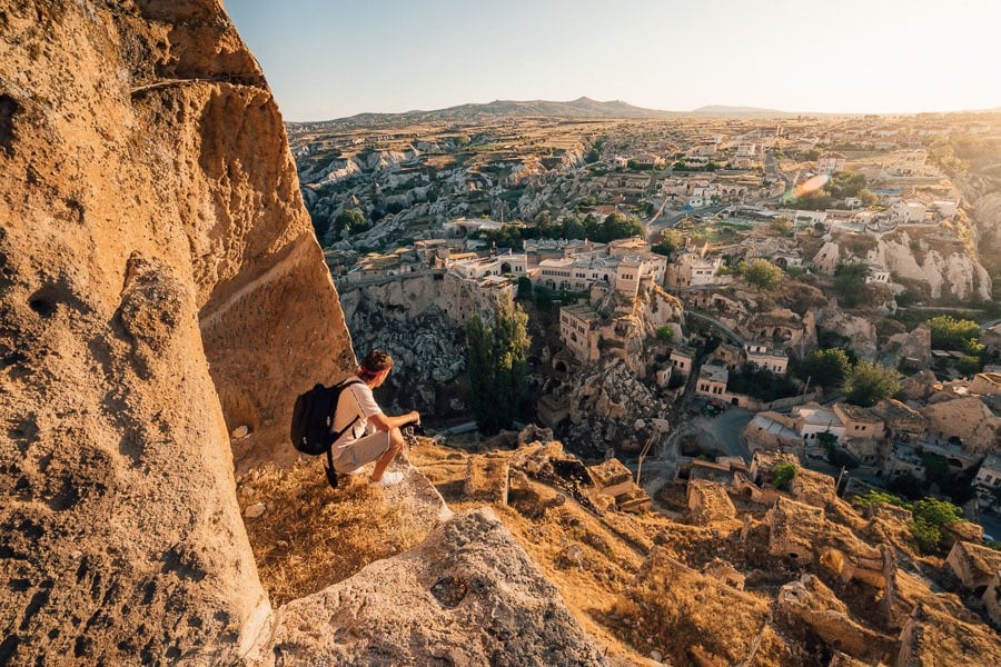 a man sitting on top of a cliff.