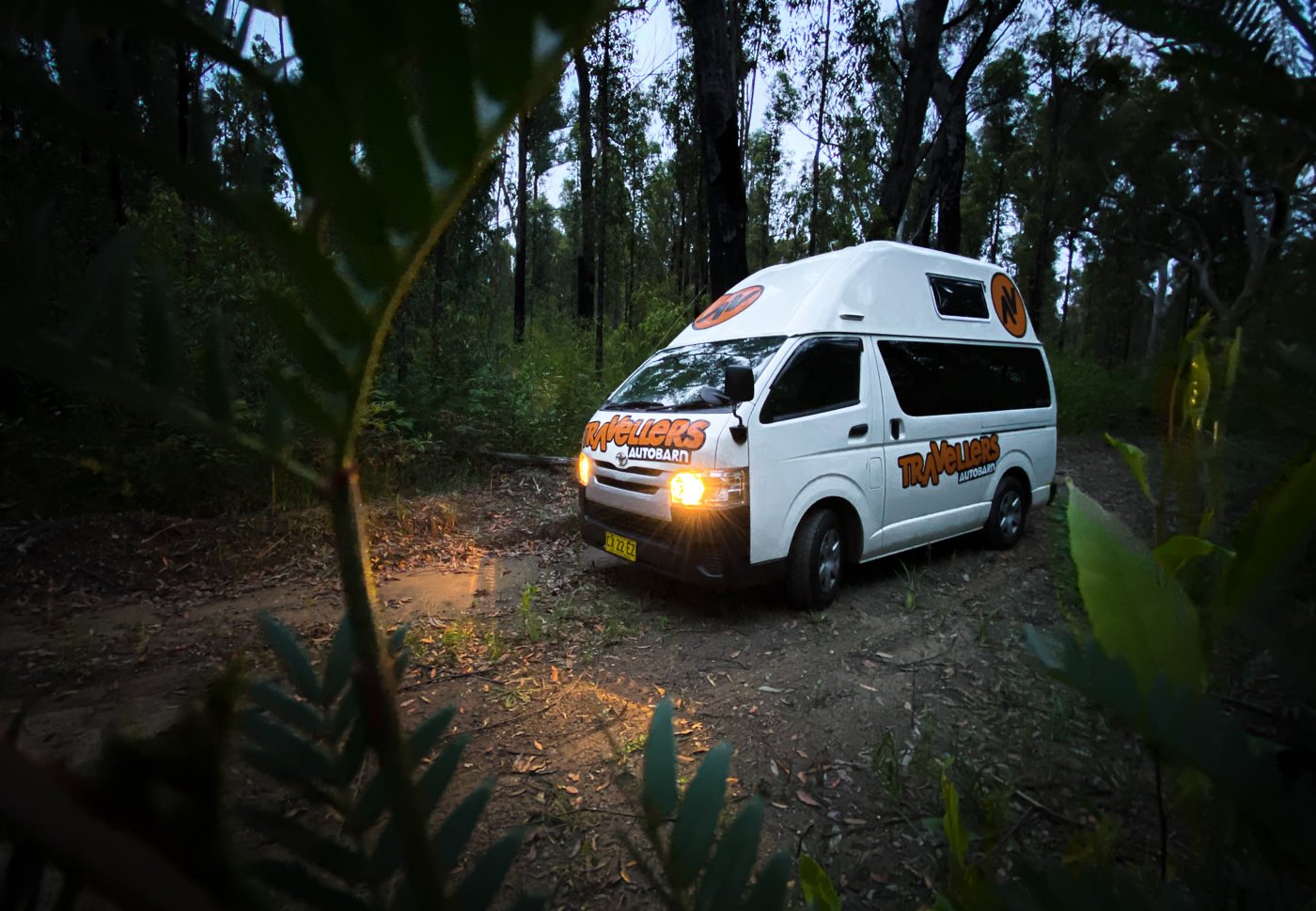 a white van parked in the middle of a forest