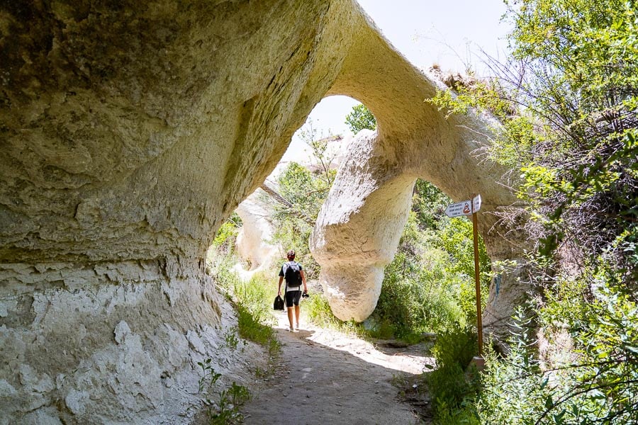 a couple of people walking down a dirt path.